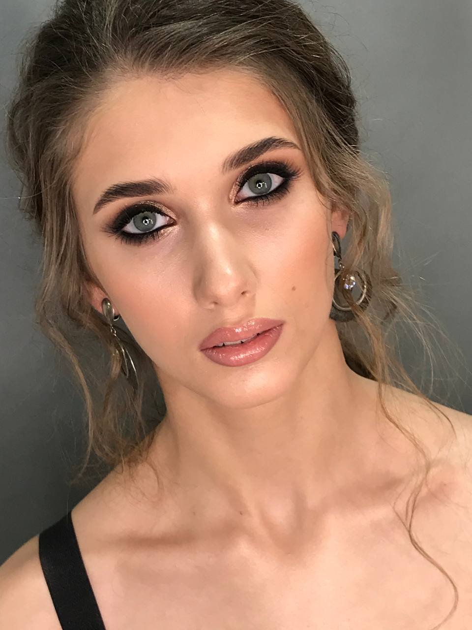 Tiefschwarzes Smokey Eye Make-up mit nudefarbenen Lippen und goldenen Creolen
