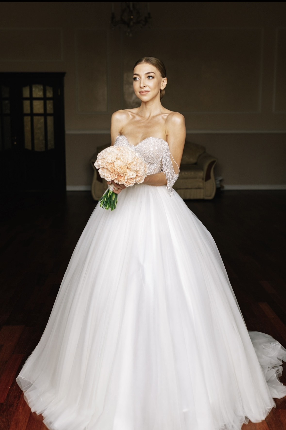 Mariée en robe princesse tenant son bouquet, maquillage et coiffure de mariée par Elena Potapenko