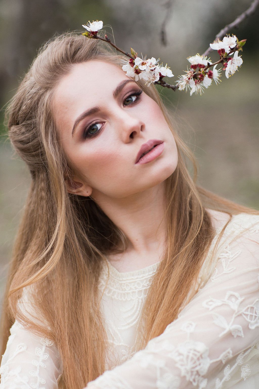 Romantisches Bridal-Make-up-Porträt mit Blütenzweigen, seitlicher Blick