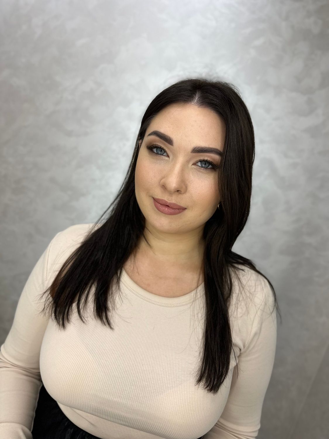 Porträt mit sanftem Glam-Braut-Make-up, glattem dunklem Haar und strahlender Haut