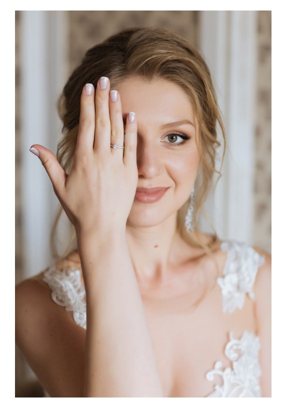 Portrait de mariée joueur, main sur l’œil montrant la bague