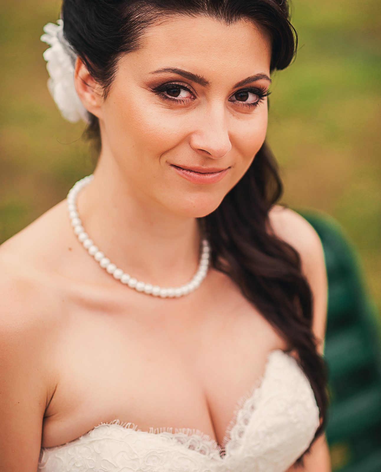 Ritratto di profilo con collana di perle: trucco costruito sulla texture della pelle prima che sul colore