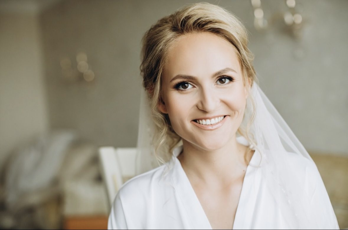 Mariée souriante en peignoir et voile, portrait pendant les préparatifs