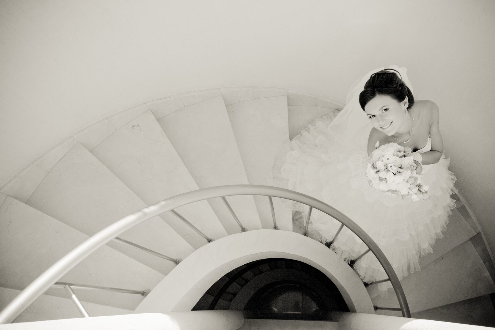 Mariée photographiée d'en haut dans un escalier en colimaçon, portrait en noir et blanc