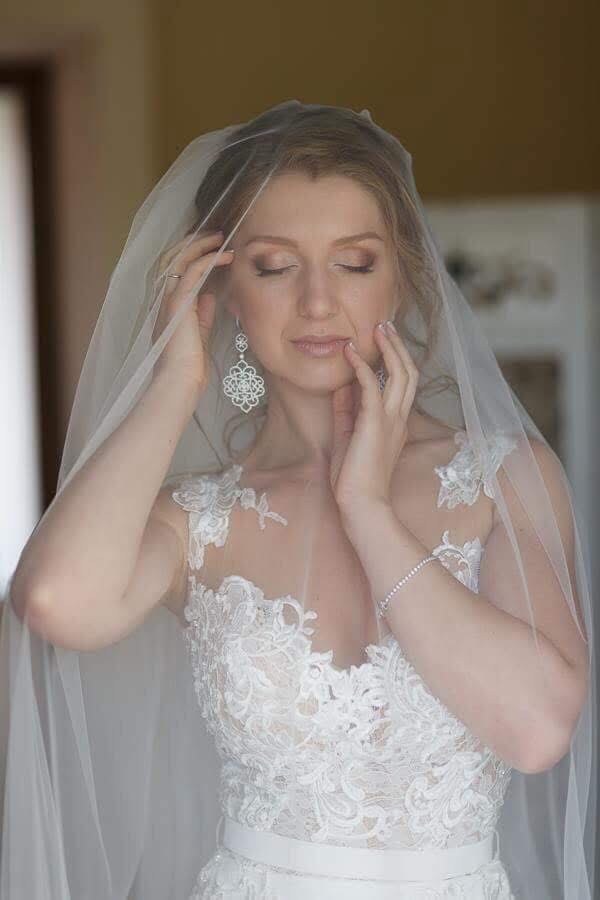 Bride in a veil with eyes closed, soft natural bridal makeup and lifted lashes by Elena Potapenko