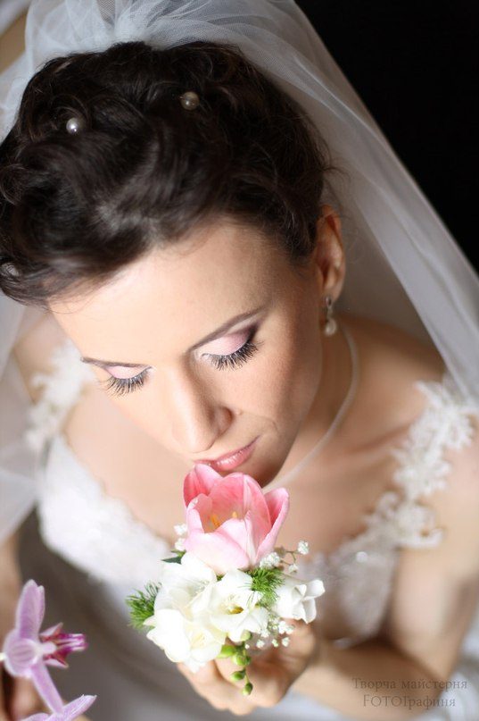 Mariée voilée avec une tulipe rose, gros plan du maquillage de mariée