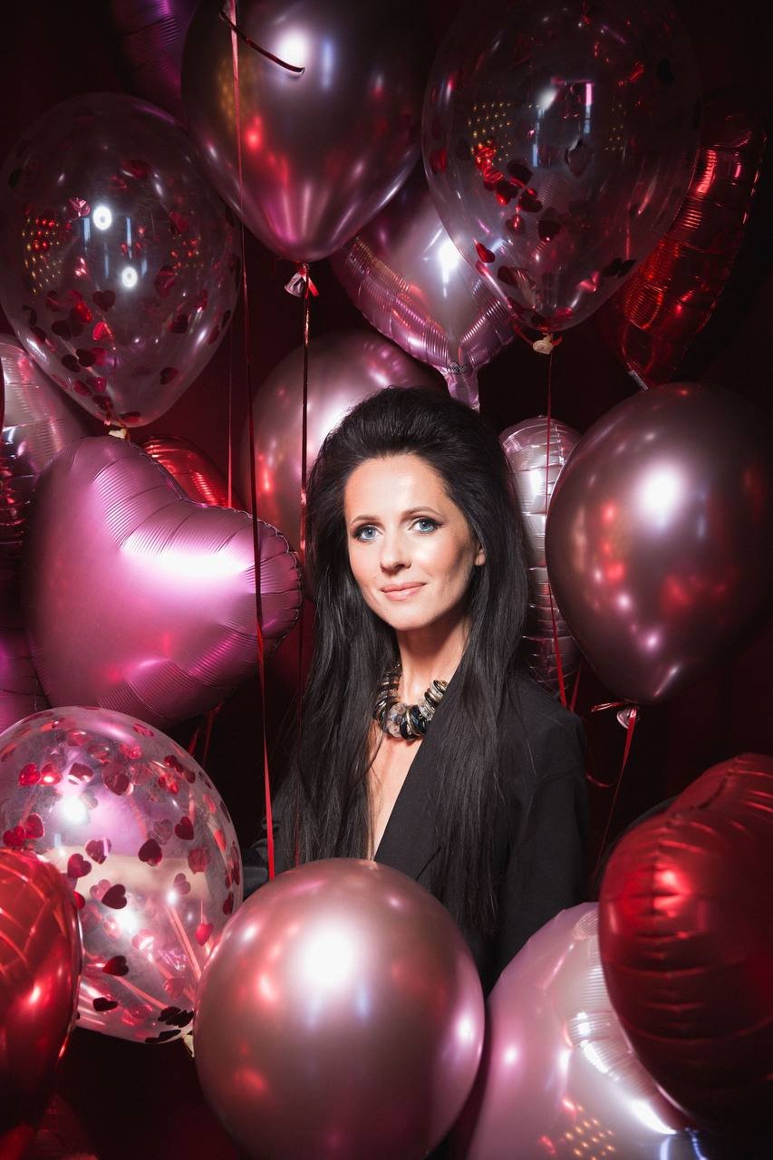 Editorial-Nahporträt umgeben von rosa und roten Ballons