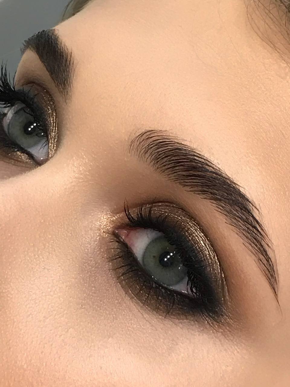 Primo piano di un trucco occhi smokey oro e bronzo