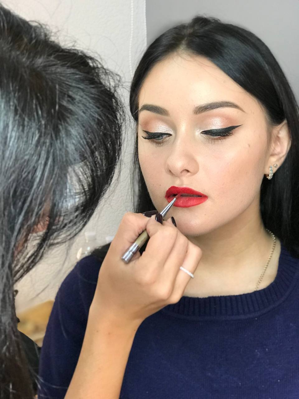 Momento backstage durante l'applicazione di un rossetto rosso deciso